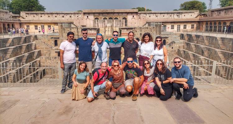 Reisegruppe posiert auf den massiven terrassierten Mauern des Stufenbrunnens Chand Baori.