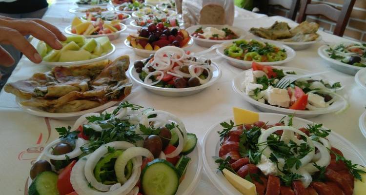 Een assortiment van traditionele gerechten op een tafel, inclusief salades en verse groenten.