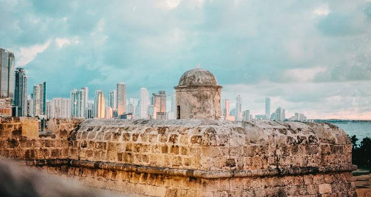 Bastion de pierre du mur historique de Carthagène avec l'horizon moderne qui s'élève au-delà de la baie au crépuscule
