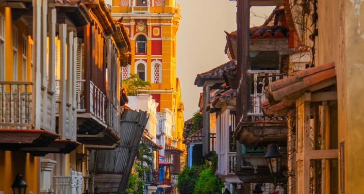 Rue coloniale colorée encadrant le clocher orné de la cathédrale de Carthagène au coucher du soleil