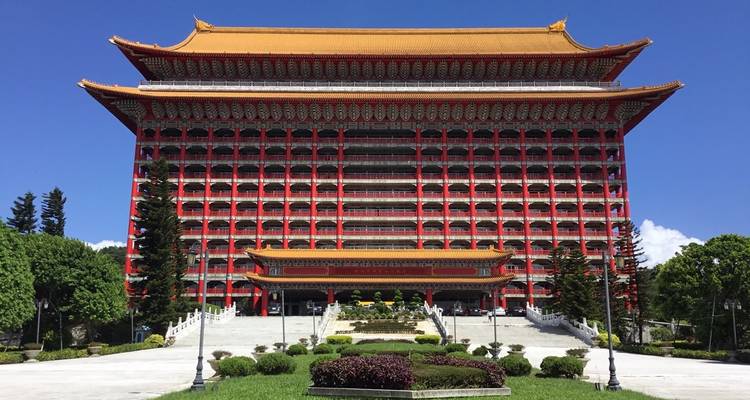 Groot hotel met traditionele Aziatische architectuur en prachtig aangelegde tuinen.