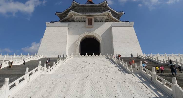Monumentaal wit stenen gebouw met een grote trap en decoratieve beeldhouwwerken.