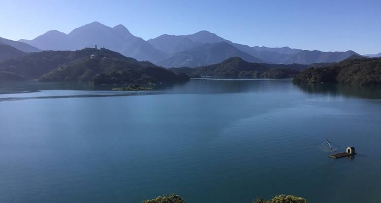 Vredig uitzicht op het meer met omringende bergen onder heldere luchten.