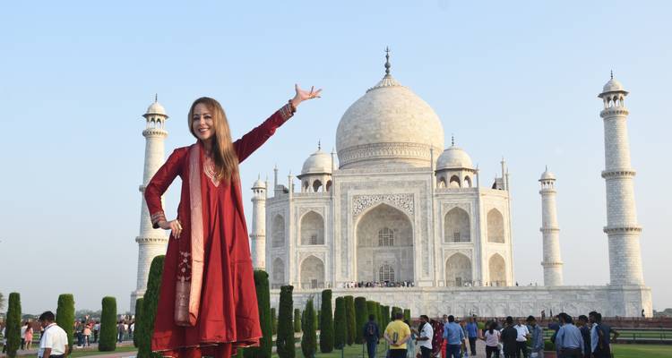 Frau posiert vor dem Taj Mahal.
