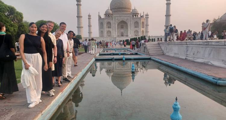 Eine Gruppe von Menschen posiert vor dem Taj Mahal.