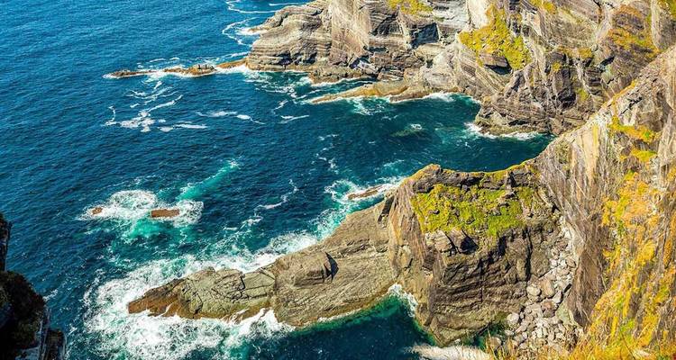 Acantilados dramáticos del Atlántico y olas turquesas a lo largo de la costa accidentada del Anillo de Kerry en Irlanda.