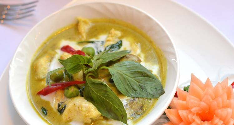 Close-up of a traditional Thai dish garnished with basil.