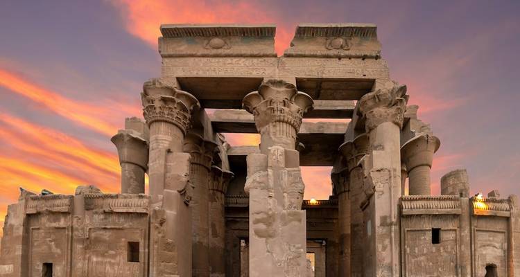 Ancient Egyptian temple with detailed carvings at sunset.