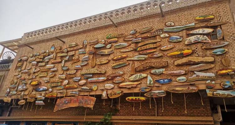A wall covered in colorful artistic plaques.
