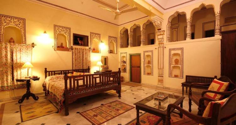 Traditionele kamerinrichting in een erfgoedhotel met sierlijke meubels.