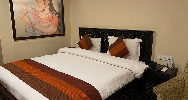 Habitación de hotel con arte tradicional y ropa de cama.