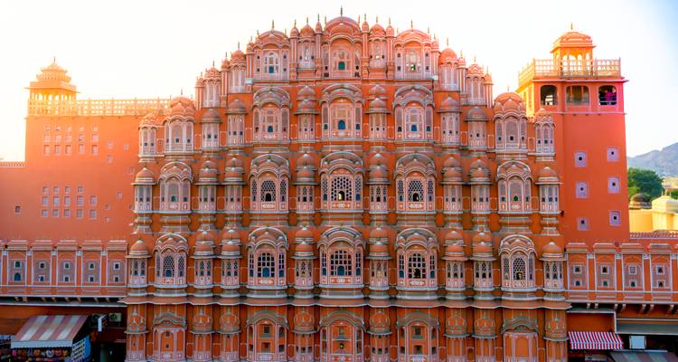 Vista frontal del icónico Hawa Mahal de Jaipur brillando con la cálida luz del amanecer.