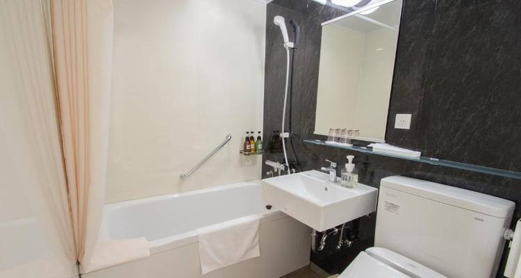 Badezimmer mit Badewanne und schwarzer Marmorwand.