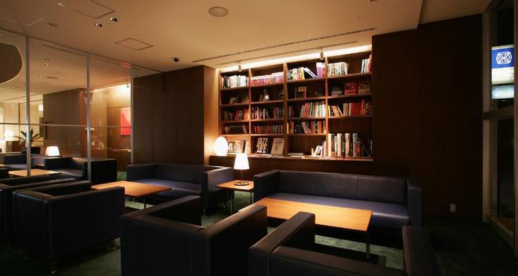 Hotellobby mit Bücherregalen und Sitzbereich.