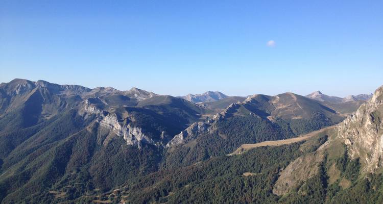 Vue panoramique d'une chaîne de montagnes sous un ciel bleu dégagé.