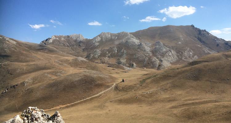 Paysage aride avec des collines stériles et un ciel dégagé.