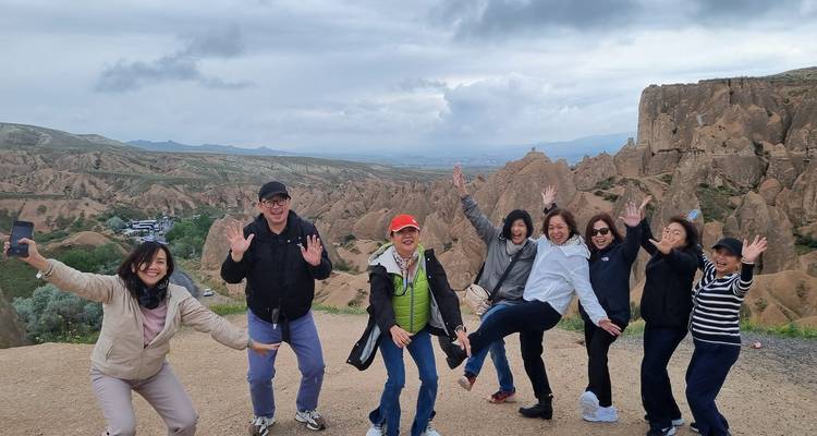 Happy group posing energetically with unique rock formations.