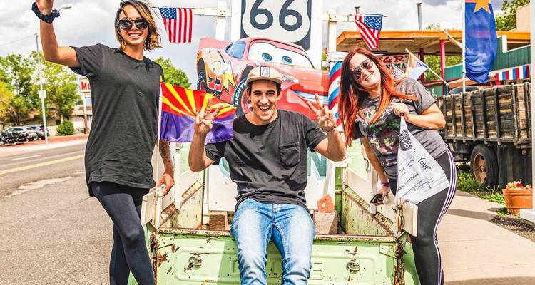 Groep mensen die poseren voor een Route 66 bord.