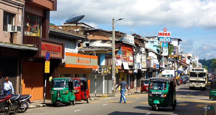 Straßenansicht mit bunten Tuk-Tuks und Geschäften.