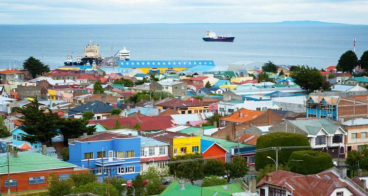 Les toits en patchwork colorés de Punta Arenas s'étendant vers le détroit de Magellan avec des navires en mer.