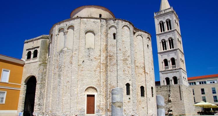 Kreisförmige Kirche des Heiligen Donatus und hoher Glockenturm vor tiefblauem Himmel in Zadar