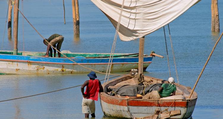 Mensen en lokale boten op een rustig wateroppervlak.