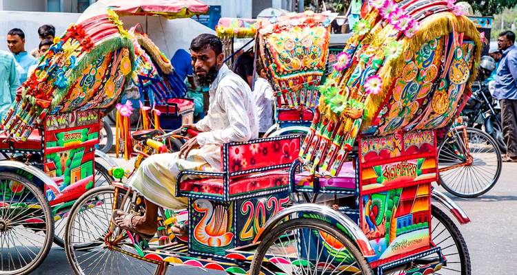 Des rickshaws colorés dans une rue animée.