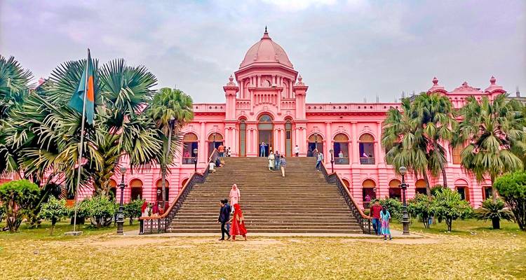 Palais rose avec des marches entouré de gens.