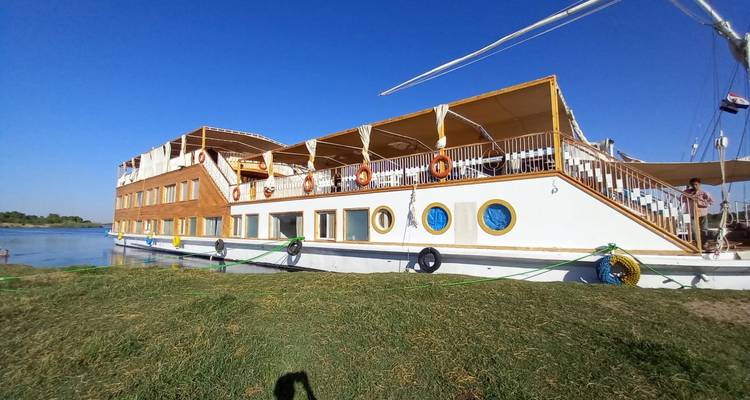 Großes Flussboot mit mehreren Decks am Flussufer angelegt.