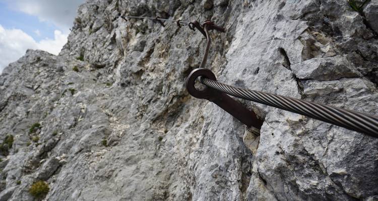 Rotswand met klimkabel beveiligd met ankers.