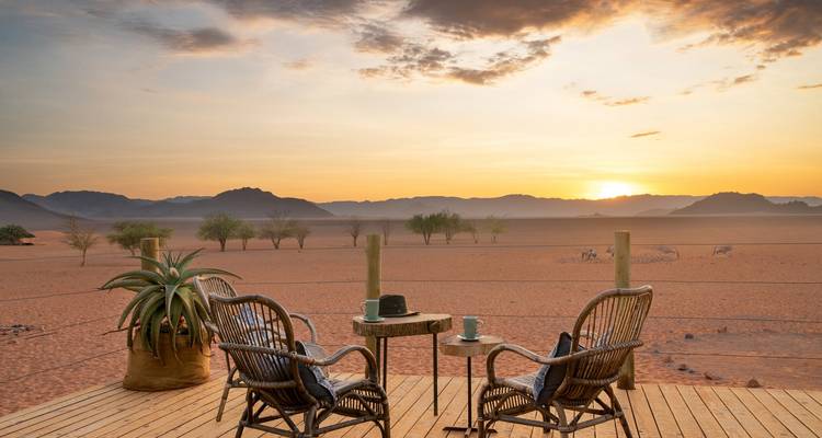 Terrasse avec des chaises donnant sur un magnifique coucher de soleil dans le désert.