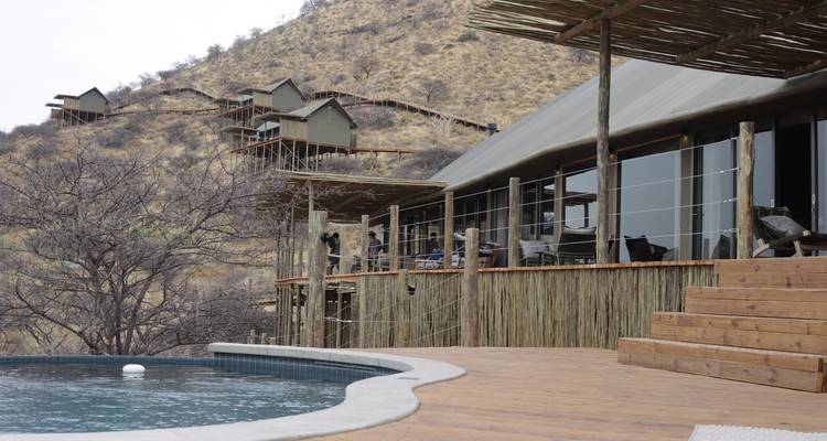 Lodge de luxe avec piscine donnant sur un paysage montagneux.