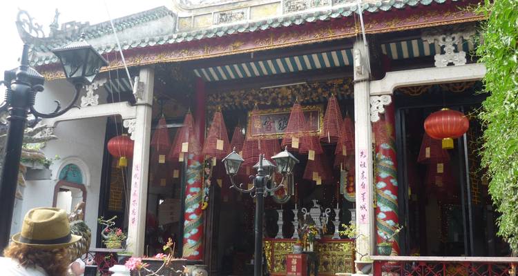 Sierlijk tempelgebouw met verzorgde tuinen en tropische planten.