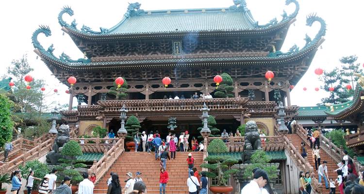 Crowded temple with intricate architecture and lanterns.