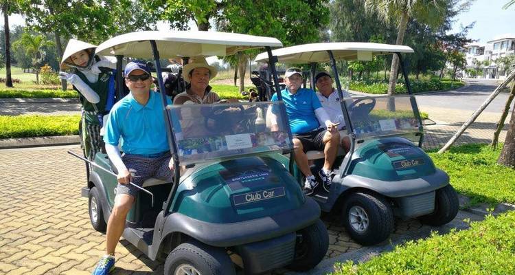 Groep mannen zittend in golfkarretjes op een zonnige dag