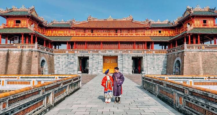Zwei Menschen in traditioneller Kleidung am Eingang zur Kaiserstadt in Hue.