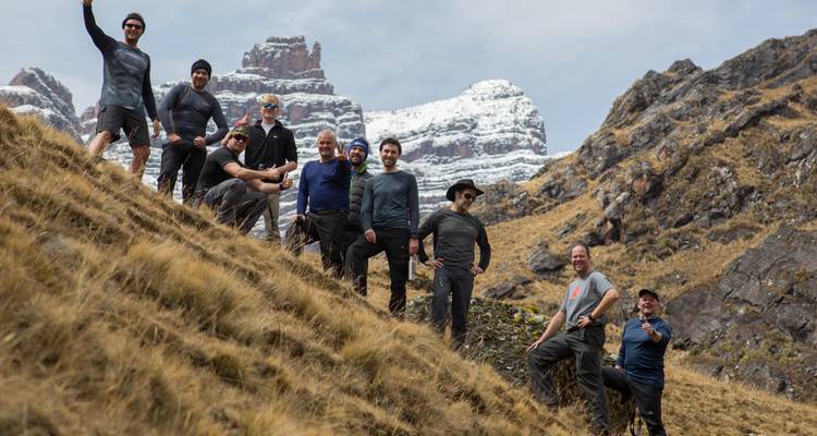 Group of hikers posing on a mountain trail near rocky terrain.