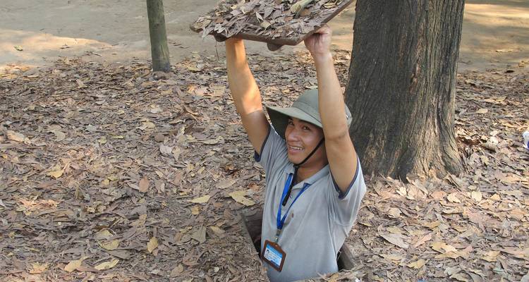 Man die tevoorschijn komt uit een kleine opening in de bosgrond.