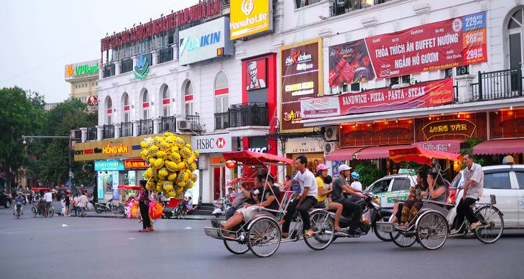 Fietsen op een drukke straat met winkels en bewegwijzering.