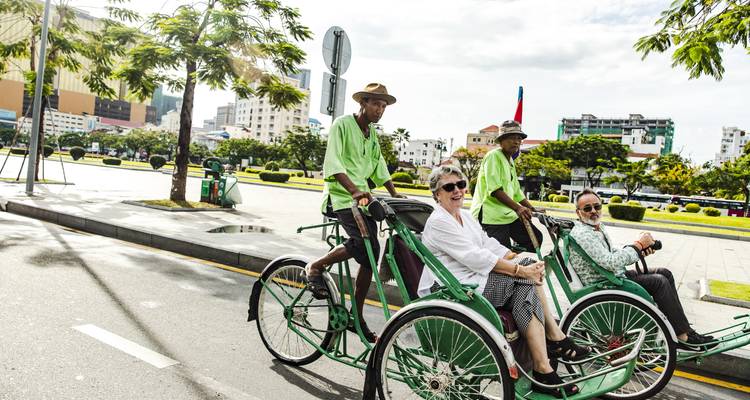 Mensen die cyclo's berijden op een straat met groen in Vietnam.
