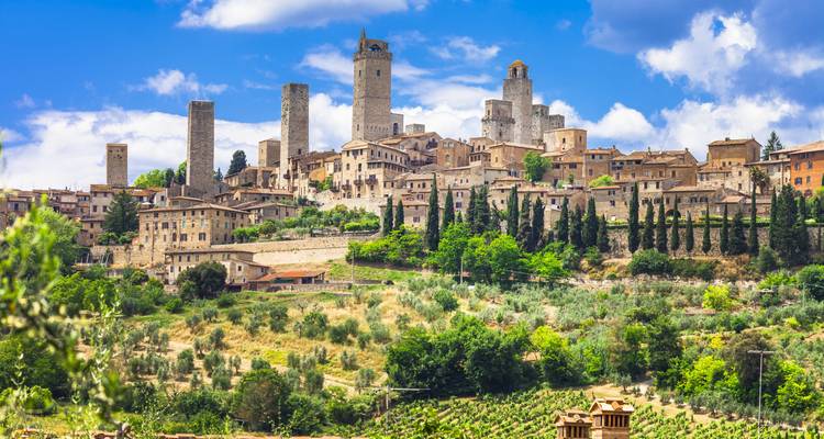 Ville médiévale perchée de San Gimignano avec ses nombreuses tours de pierre s'élevant au-dessus de la campagne toscane vallonnée.