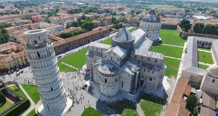Vue aérienne de la Piazza dei Miracoli de Pise montrant la Tour penchée, la cathédrale et le baptistère avec des foules en contrebas.
