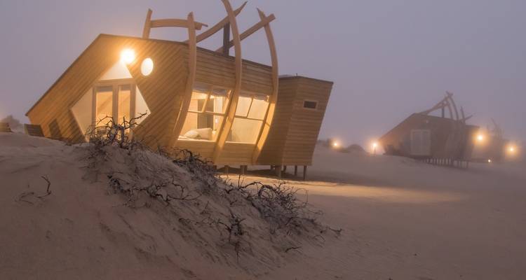 Malerische Aussicht auf kuppelförmige Gebäude in einer nebligen Wüste.