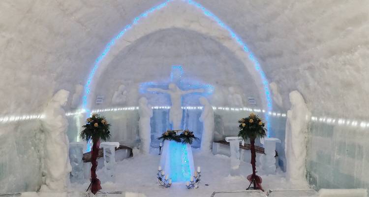 IJskapel met verlichte kruis en beelden binnen