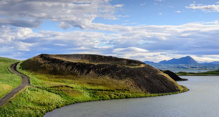 Volcanic crater surrounded by water and scenic landscape.