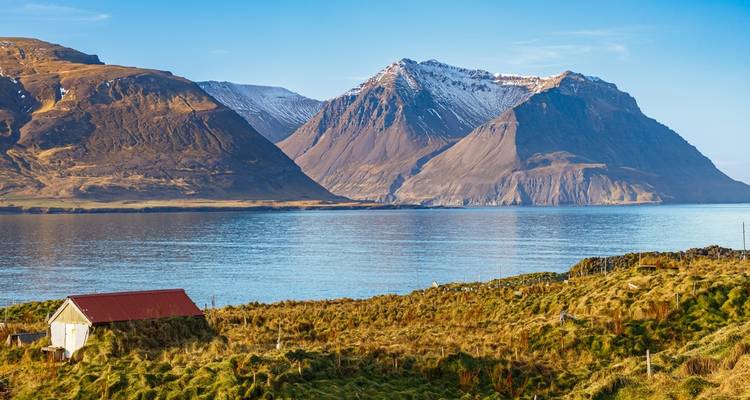 Snow-capped mountains by a body of water.