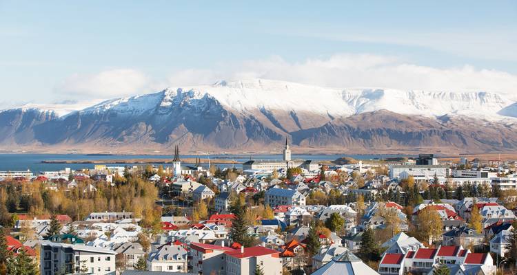Panoramic view of Reykjavik with snowy mountains in the background.