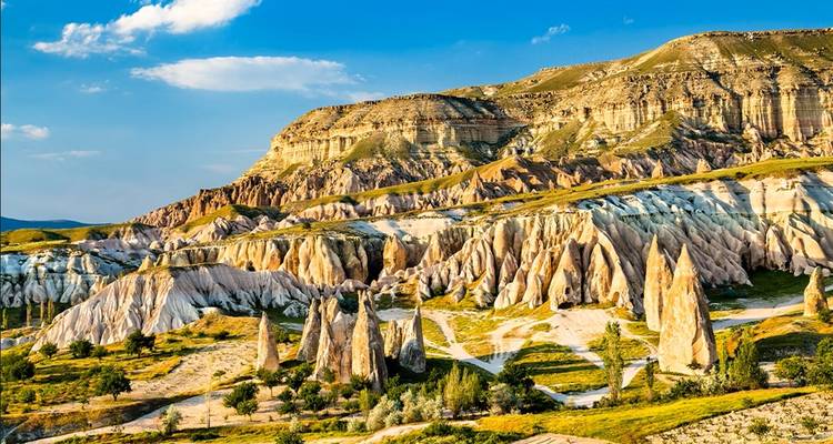 Kleurrijke rotsformaties en canyons onder een blauwe hemel.