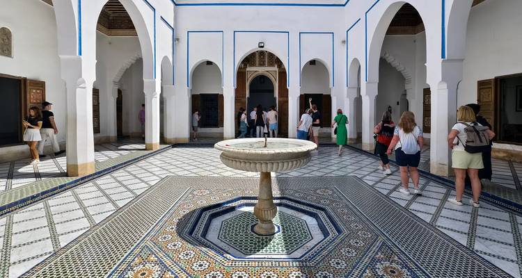 Palace courtyard with people around a fountain.