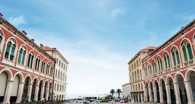 La place Prokurative de Split, encadrée par des bâtiments en arcade assortis donnant sur la mer, offre un spectacle de couleurs.